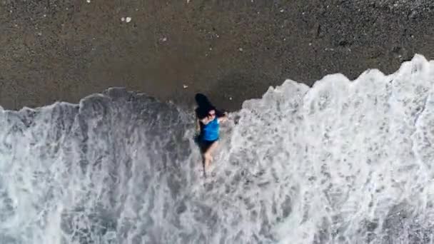 Женщина лежит на берегу моря под волнами. Концепция путешествий, отдыха, отпусков . — стоковое видео