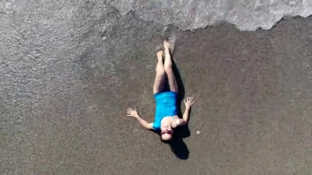 Vlny se pere o ženu v plavkách. — Stock video