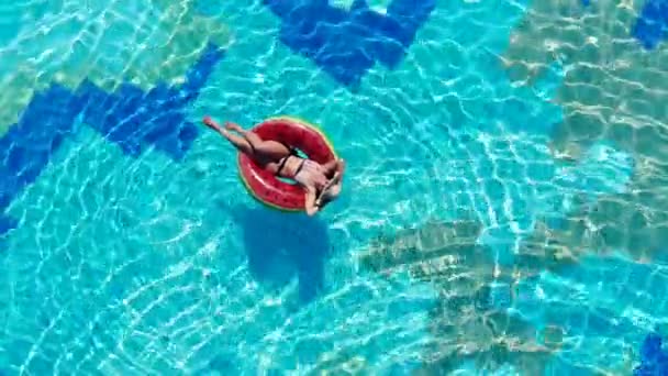 En dam ligger på en Badring i poolen. Carefree Lady under sommarlov. — Stockvideo