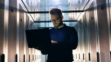 Bilgisayarda çalışan erkek teknisyenli sunucu odası