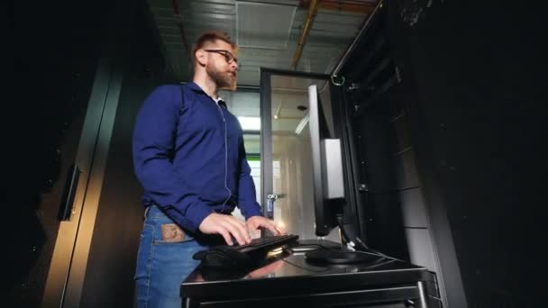 Serverraum mit einem Mann am Computer — Stockvideo