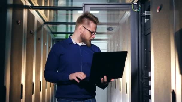 Servrar drivs genom en bärbar dator av en man — Stockvideo