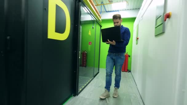 En man med en bärbar dator observerar ett rum med Server block — Stockvideo