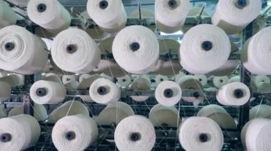 Dikiş makaraları dönüyor. Endüstriyel tekstil fabrikası