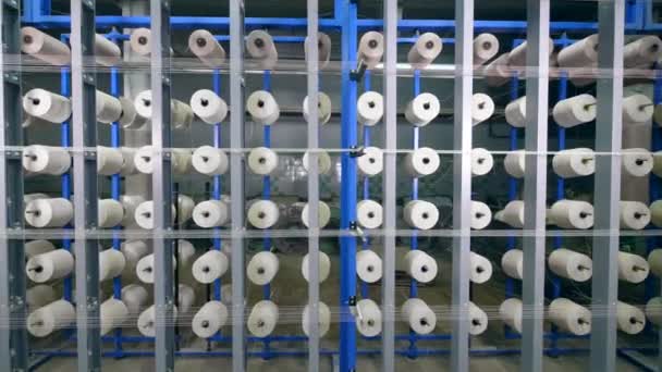 Un montón de carretes de costura unidos a la máquina industrial. Fábrica textil industrial — Vídeo de stock