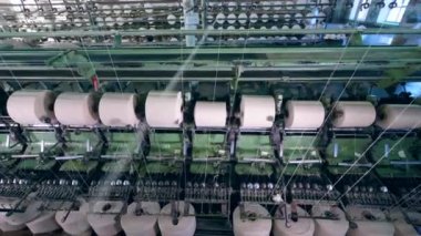 Fabrika makinesi beyaz ipliklerle dikiş dikiyor. Endüstriyel tekstil ekipmanları