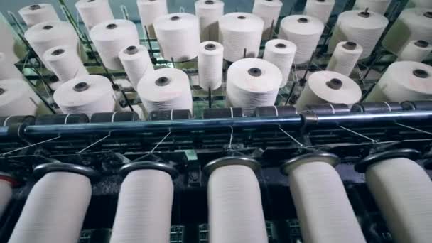 Los hilos blancos se están desenrollando de carretes giratorios — Vídeo de stock