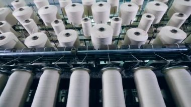 Üzerlerinde beyaz iplikler olan makaraları dikme. Endüstriyel tekstil fabrikası