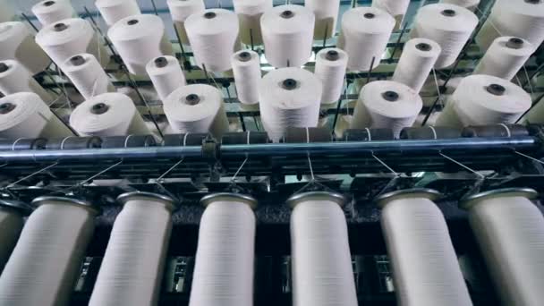 Het afstemmen van rollen met witte draden op hen. Industriële textielfabriek — Stockvideo