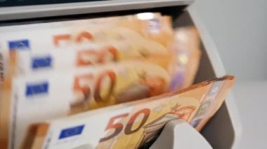 Bankadaki sayma makinesinde kontrol edilen nakit para.