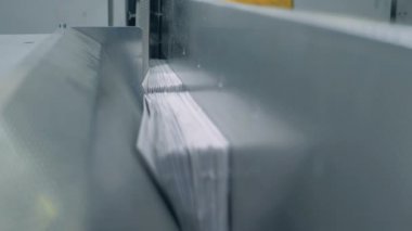 Yığılmış sayfalar parçaları endüstriyel konveyör boyunca hareket ediyor. Sahte haber konsepti.