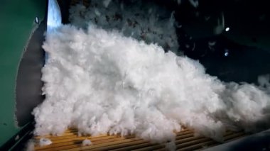 Bir fabrikada bir makinede dönen beyaz sentetik kumaş.
