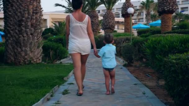 Жінка і її син ходять до готелю з пляжу . — стокове відео