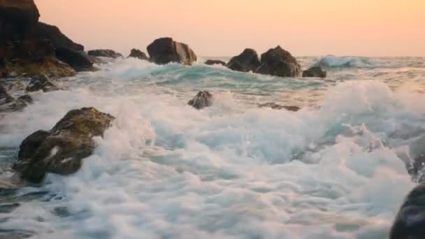 Olas salpicando sobre rocas en una playa . — Vídeo de stock