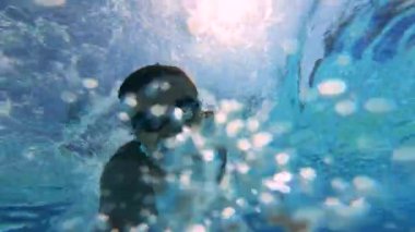 Bir adam havuzda su altında yüzerken bir kamera tutar. Yaz tatili konsepti.