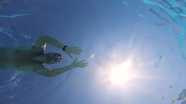 Um turista nada em uma grande piscina, usando óculos . — Vídeo de Stock