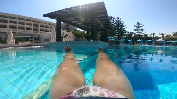 Nő pihen a medencében, élvezve nyaralását. A nyári szabadságolási koncepció. — Stock videók