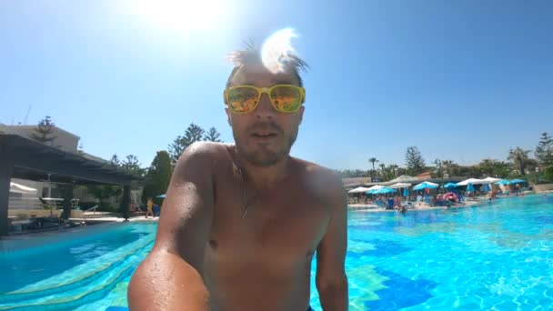 Mann mit Brille springt in einen Pool. — Stockvideo
