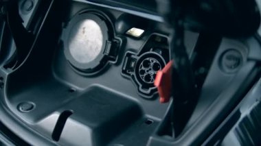 Yenilikçi elektrikli hibrid araba şarj. Kişi modern bir istasyonda elektromobil şarj.