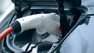 Takılı kablolu şarj istasyonunda modern elektrikli otomobil.