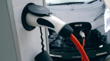 Beyaz şarj cihazı elektromobil ile çalışır, şarj. Yenilikçi elektrikli hibrid araba şarj.