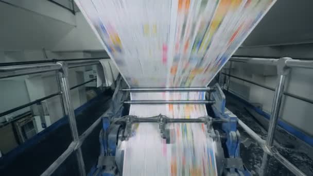 La macchina poligrafica sta rotolando carta stampata a colori — Video Stock