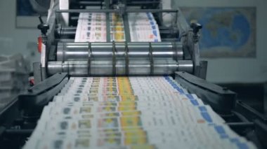 Basılı dergiler haddeleme makinesi boyunca hareket ediyor