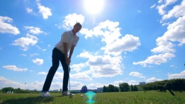 Golf oyuncusu gücü ile topa vuruyor