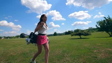 Genç bayan saha nın her yerinde golf aksesuarları taşıyor.