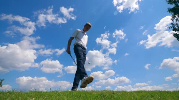 Человек играет с клюшкой для гольфа и мячом — стоковое видео