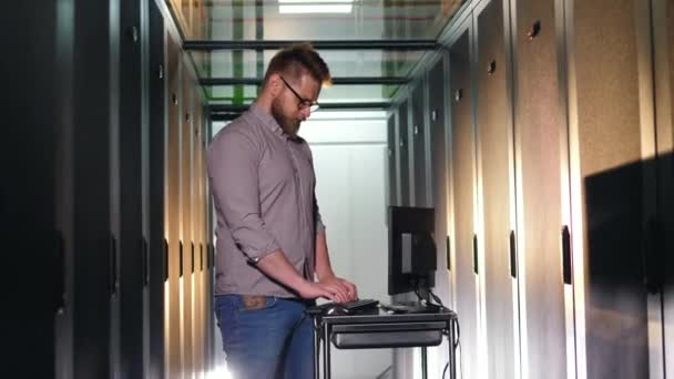 Programador masculino trabalha com um equipamento de verificação de computador em um data center . — Vídeo de Stock