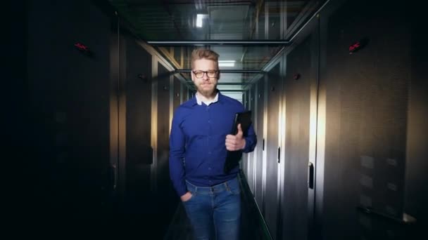 Programmeur houdt een laptop, wandelen in een server kamer. IT support concept. — Stockvideo