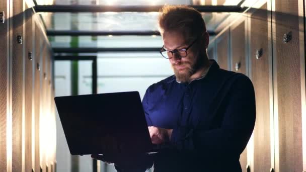 Tipo de trabalhador de data center em um laptop. Técnico de servidor trabalhando em data center moderno . — Vídeo de Stock