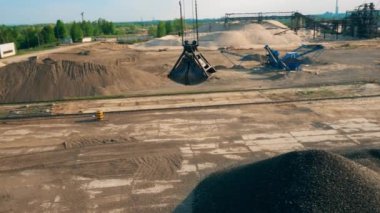 Ezilmiş taşlı bir kova onları rıhtımda boşaltır..