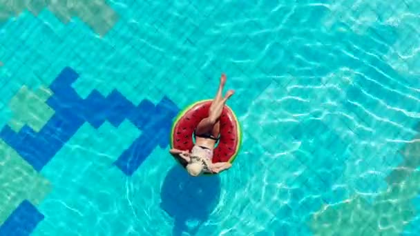 Žena odpočívá na gumovém prstenci v bazénu. — Stock video
