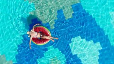 Kadın büyük bir havuzda, bir yüzük üzerinde yüzen rahatlatır.