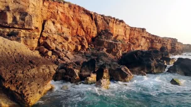 Ocean Waves neasr Rocks på en solnedgång bakgrund. Ocean Shore, Wild Nature Concept. — Stockvideo