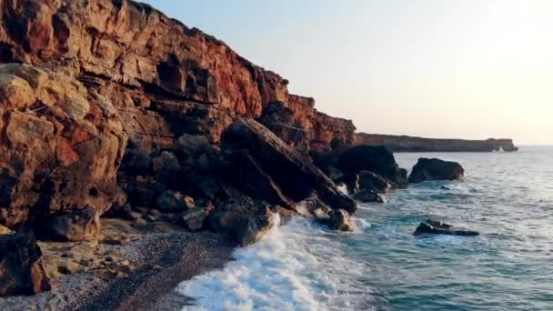 Kayalıklar ve gün batımı arka plan üzerinde mavi bir deniz. Okyanus kıyısı, vahşi doğa konsepti. — Stok video