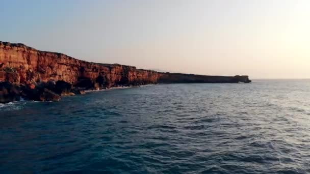 Pedras com ondas batendo em um fundo por do sol . — Vídeo de Stock