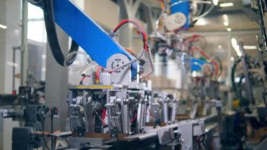 Fabrika cihazı bir üretim merkezinde bir konveyör üzerine karton koyar.
