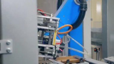 Bir fabrikada robotik üretim hattı çalışması, otomatik montaj hattı bir konveyör üzerine karton levhalar koyarak.