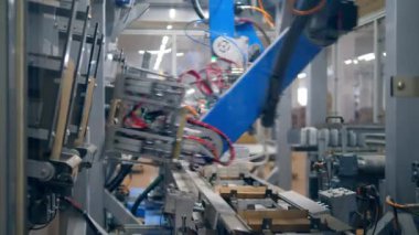 Bitki konveyörü karton kutuları art arda taşır. Robotik üretim hattı.