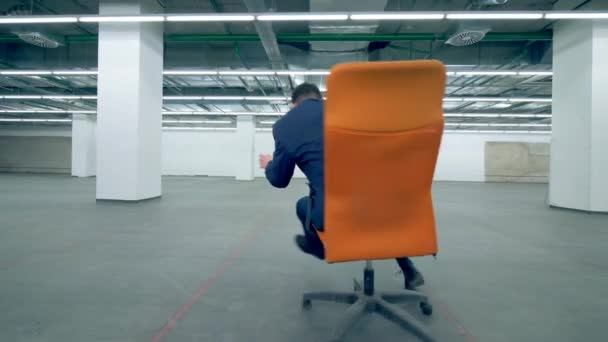 Un homme d'affaires en costume s'amuse dans une chaise roulante — Video