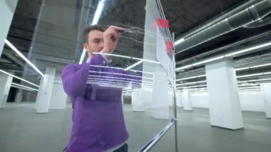 Bina planı bir erkek uzman tarafından denetleniyor.