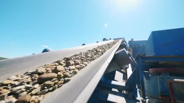 Schutt bewegt sich auf einem Förderband eines Brechers. Ausrüstung für den Bergbau. — Stockvideo