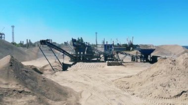 Büyük kırma makinesi su kenarındaki bir taş ocağında çalışır. Endüstriyel madencilik kavramı.