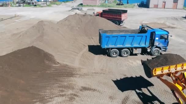 Sárga traktor betölti a teherautó zúzott kövek. — Stock videók