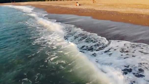 Yunanistan'da kumlu bir plajda mavi deniz sıçrayan. Havadan görünüm. — Stok video