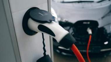 Şarj ekipmanları siyah elektrikli araba ile çalışır. Elektrikli araç şarj.