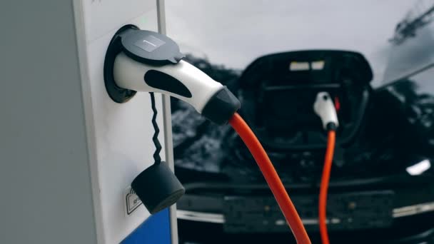 Carga de vehículos eléctricos. El moderno equipo de carga funciona con eletromobile negro . — Vídeo de stock